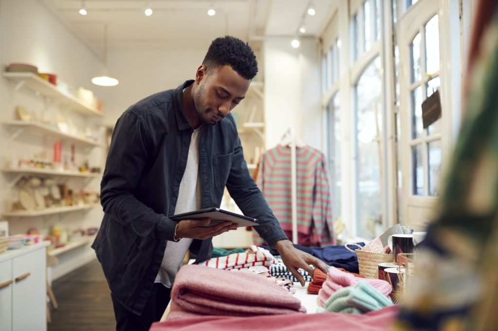Male Small Business Owner Checks Stock In Shop Using Digital Tablet public relations, small business, branding, media outreach, community engagement