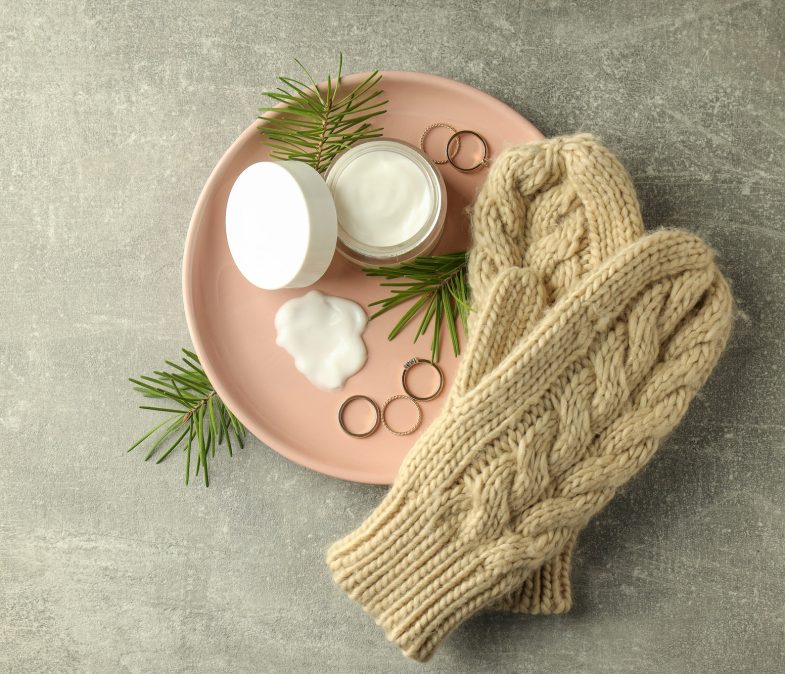 Concept of winter cosmetic products on gray textured table