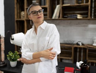 strong and independent successful woman leader stands thinking among the office