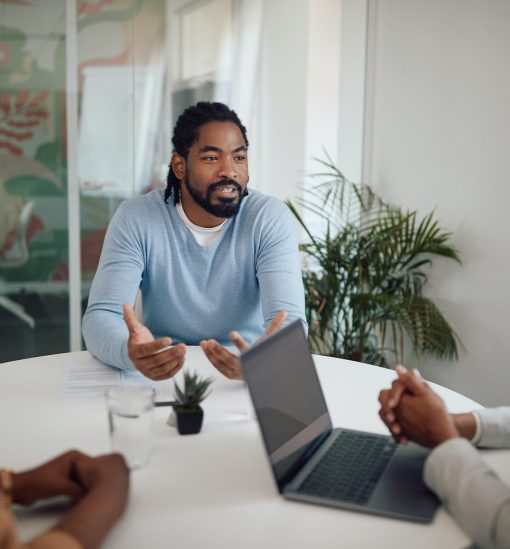 Young black man talking to human resource team during job interview in the office.