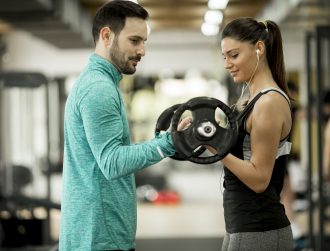 Young woman with personal trainer in gym